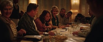 Movie still from “Rose” (2022), directed by Niels Arden Oplev – A group of people sitting at a dinner table; Medium shot, Over the shoulder angle