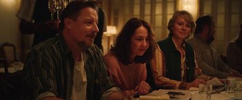 Movie still from “Rose” (2022), directed by Niels Arden Oplev – A man and a woman sitting next to each other at a table; Medium shot, Over the shoulder angle