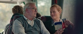 Movie still from “Rose” (2022), directed by Niels Arden Oplev – An older man and a younger woman sitting next to each other on a bus; Close Up shot, Over the shoulder angle