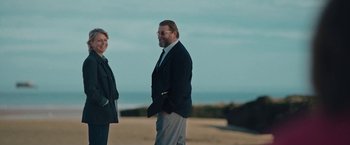 Movie still from “Rose” (2022), directed by Niels Arden Oplev – A man and a woman standing next to each other on the beach; Medium shot, Low angle