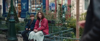 Movie still from “Rose” (2022), directed by Niels Arden Oplev – A woman and a boy sitting on top of a wooden bench; Medium shot, High angle