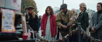 Movie still from “Rose” (2022), directed by Niels Arden Oplev – A group of people standing next to each other on a street; Medium shot, High angle