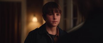 Movie still from “Rose” (2022), directed by Niels Arden Oplev – A young boy is looking into the camera; Close Up shot, Over the shoulder angle