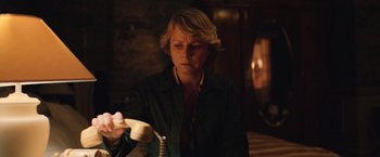 Movie still from “Rose” (2022), directed by Niels Arden Oplev – A woman in a black jacket is holding a phone; Medium shot, Over the shoulder angle