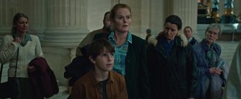 Movie still from “Rose” (2022), directed by Niels Arden Oplev – A woman and a boy standing next to each other in a building; Medium shot, Low angle