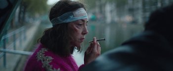 Movie still from “Rose” (2022), directed by Niels Arden Oplev – A woman with bandages on her head smoking a cigarette; Close Up shot, Over the shoulder angle