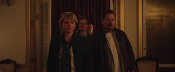 Movie still from “Rose” (2022), directed by Niels Arden Oplev – A group of people standing next to each other in a room; Medium shot, Over the shoulder angle
