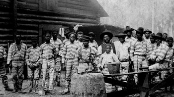 Movie still from “13th” (2016), directed by Ava DuVernay – A group of men standing next to each other in front of a building; Wide shot, High angle