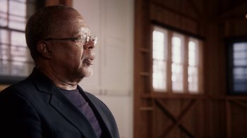 Movie still from “13th” (2016), directed by Ava DuVernay – An older man wearing glasses and a suit; Close Up shot, Low angle