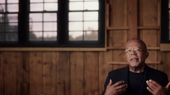 Movie still from “13th” (2016), directed by Ava DuVernay – An older man wearing glasses talking to someone in front of a window; Close Up shot, Over the shoulder angle