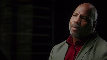 Movie still from “13th” (2016), directed by Ava DuVernay – A man in a suit and red shirt is looking up; Close Up shot, Low angle