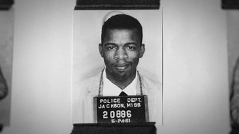Movie still from “13th” (2016), directed by Ava DuVernay – A black and white photo of an african - american man in jail; Extreme Close Up shot, Overhead angle