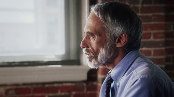 Movie still from “13th” (2016), directed by Ava DuVernay – An older man with a gray beard looking out a window; Close Up shot, Over the shoulder angle