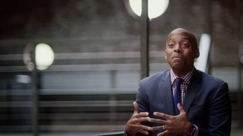 Movie still from “13th” (2016), directed by Ava DuVernay – A man in a suit and tie talking to a camera; Medium shot, Over the shoulder angle