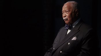 Movie still from “13th” (2016), directed by Ava DuVernay – An older man wearing a suit and a bow tie; Close Up shot, Low angle