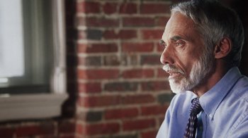 Movie still from “13th” (2016), directed by Ava DuVernay – An older man wearing a neck tie looking off into the distance; Close Up shot, Over the shoulder angle