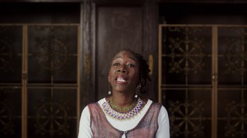 Movie still from “13th” (2016), directed by Ava DuVernay – A woman wearing a necklace and a brown vest; Close Up shot, Low angle