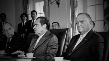 Movie still from “13th” (2016), directed by Ava DuVernay – A black and white photo of men in suits and ties sitting at a table; Medium shot, Over the shoulder angle