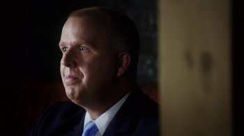 Movie still from “13th” (2016), directed by Ava DuVernay – A man wearing a suit and tie looking to his left; Close Up shot, Over the shoulder angle