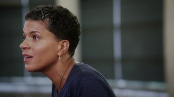 Movie still from “13th” (2016), directed by Ava DuVernay – A person with a short curly hair wearing a blue shirt; Close Up shot, Over the shoulder angle