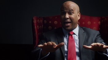 Movie still from “13th” (2016), directed by Ava DuVernay – A bald man in a suit and red neck tie; Medium shot, Low angle
