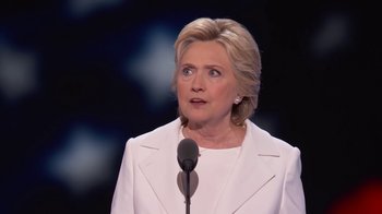 Movie still from “13th” (2016), directed by Ava DuVernay – A woman in a white suit is speaking at a podium; Close Up shot, Low angle