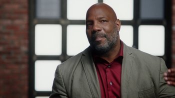 Movie still from “13th” (2016), directed by Ava DuVernay – A man in a suit and red shirt is posing for a picture; Close Up shot, Low angle