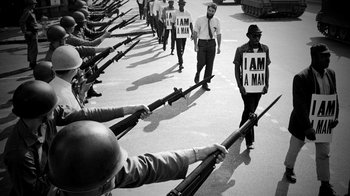 Movie still from “13th” (2016), directed by Ava DuVernay – A black and white photo of men holding guns; Medium shot, Low angle
