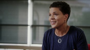 Movie still from “13th” (2016), directed by Ava DuVernay – A woman sitting in front of a window smiling at the camera; Close Up shot, Low angle