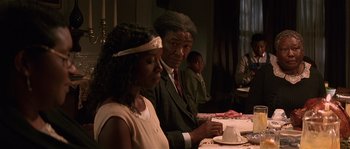 Movie still from “Rosewood” (1997), directed by John Singleton – An older man and a young woman sitting at a dinner table; Medium shot, Over the shoulder angle