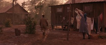 Movie still from “Rosewood” (1997), directed by John Singleton – A man walking in front of a cabin in the woods; Wide shot, Over the shoulder angle