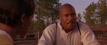 Movie still from “Rosewood” (1997), directed by John Singleton – A man with a beard is looking at another man; Close Up shot, Over the shoulder angle