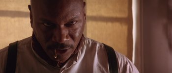 Movie still from “Rosewood” (1997), directed by John Singleton – A person with a bite of food in his mouth; Close Up shot, Low angle