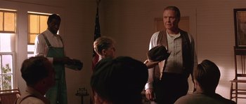 Movie still from “Rosewood” (1997), directed by John Singleton – A man is holding a hat while a woman looks at him; Medium shot, Over the shoulder angle