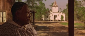 Movie still from “Rosewood” (1997), directed by John Singleton – An older woman standing in front of a church; Close Up shot, Low angle