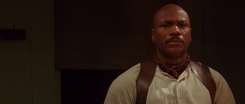 Movie still from “Rosewood” (1997), directed by John Singleton – A man in a white shirt and a brown neck tie; Close Up shot, Low angle