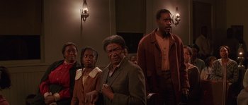 Movie still from “Rosewood” (1997), directed by John Singleton – A group of people standing in front of a wall; Medium shot, High angle