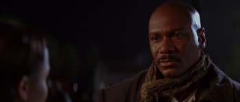 Movie still from “Rosewood” (1997), directed by John Singleton – A bald man with a scarf around his neck; Close Up shot, Low angle