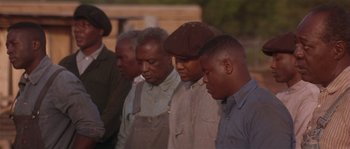 Movie still from “Rosewood” (1997), directed by John Singleton – A group of men standing next to each other; Medium shot, Over the shoulder angle
