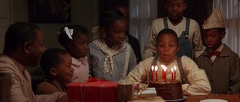 Movie still from “Rosewood” (1997), directed by John Singleton – A group of children sitting around a table with a birthday cake; Close Up shot, High angle