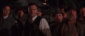 Movie still from “Rosewood” (1997), directed by John Singleton – A group of men standing next to each other in a dark room; Medium shot, Low angle