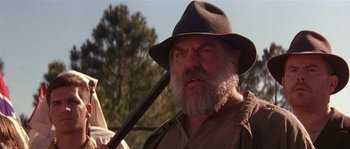Movie still from “Rosewood” (1997), directed by John Singleton – An old man with a beard and a hat holding a stick; Close Up shot, Low angle