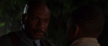 Movie still from “Rosewood” (1997), directed by John Singleton – A man in a suit stares at the camera; Close Up shot, Over the shoulder angle
