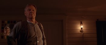 Movie still from “Rosewood” (1997), directed by John Singleton – An older man standing in a room with a light on; Medium shot, Low angle