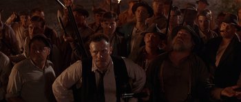 Movie still from “Rosewood” (1997), directed by John Singleton – A group of men standing next to each other holding guns; Medium shot, Low angle