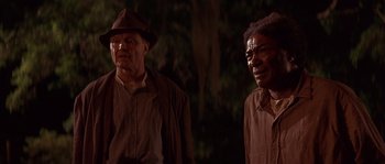 Movie still from “Rosewood” (1997), directed by John Singleton – Two men standing next to each other near a tree; Close Up shot, Over the shoulder angle