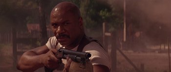 Movie still from “Rosewood” (1997), directed by John Singleton – A man holding a gun while standing in the dirt; Close Up shot, Low angle