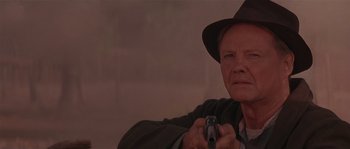Movie still from “Rosewood” (1997), directed by John Singleton – An older man holding a gun while wearing a hat; Close Up shot, Low angle