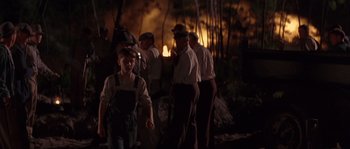 Movie still from “Rosewood” (1997), directed by John Singleton – A group of people standing around a fire; Wide shot, Over the shoulder angle