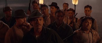 Movie still from “Rosewood” (1997), directed by John Singleton – A group of men standing next to each other in a dark room; Medium shot, Low angle